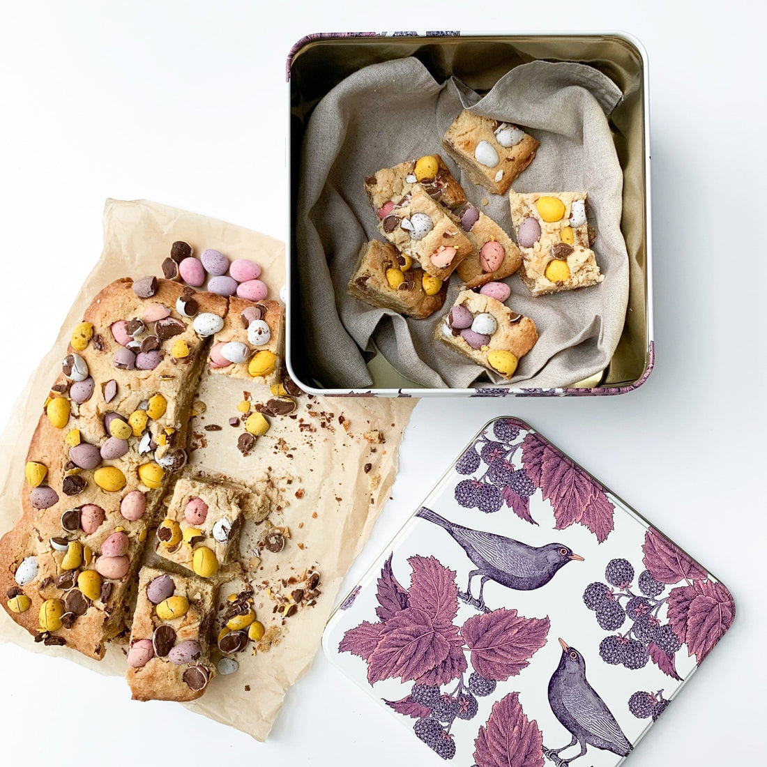 Kitchentins - Thornback and Peel Blackbird and Bramble Square Cake Tin sitting next to a Mini Egg Tray Bake