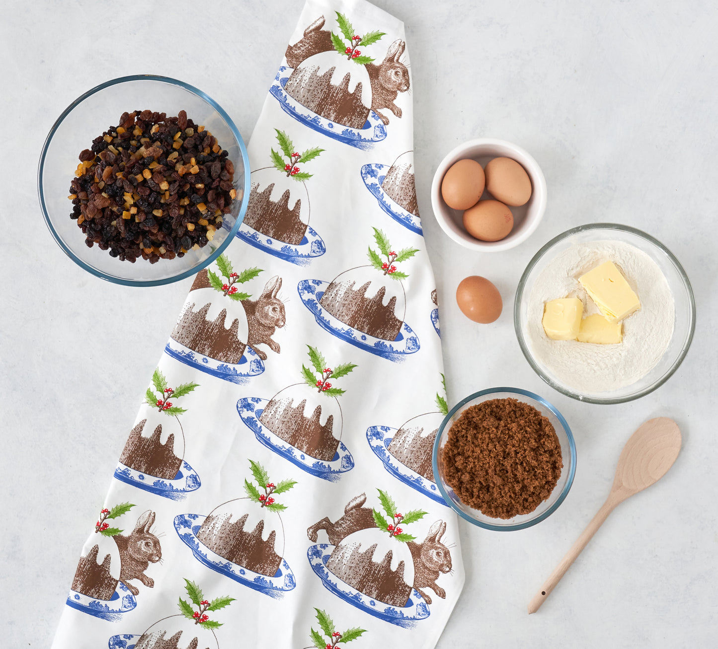 kitchentins - Thornback & Peel cotton tea towel printed with chocolate coloured rabbits amongst tasty Christmas puddings