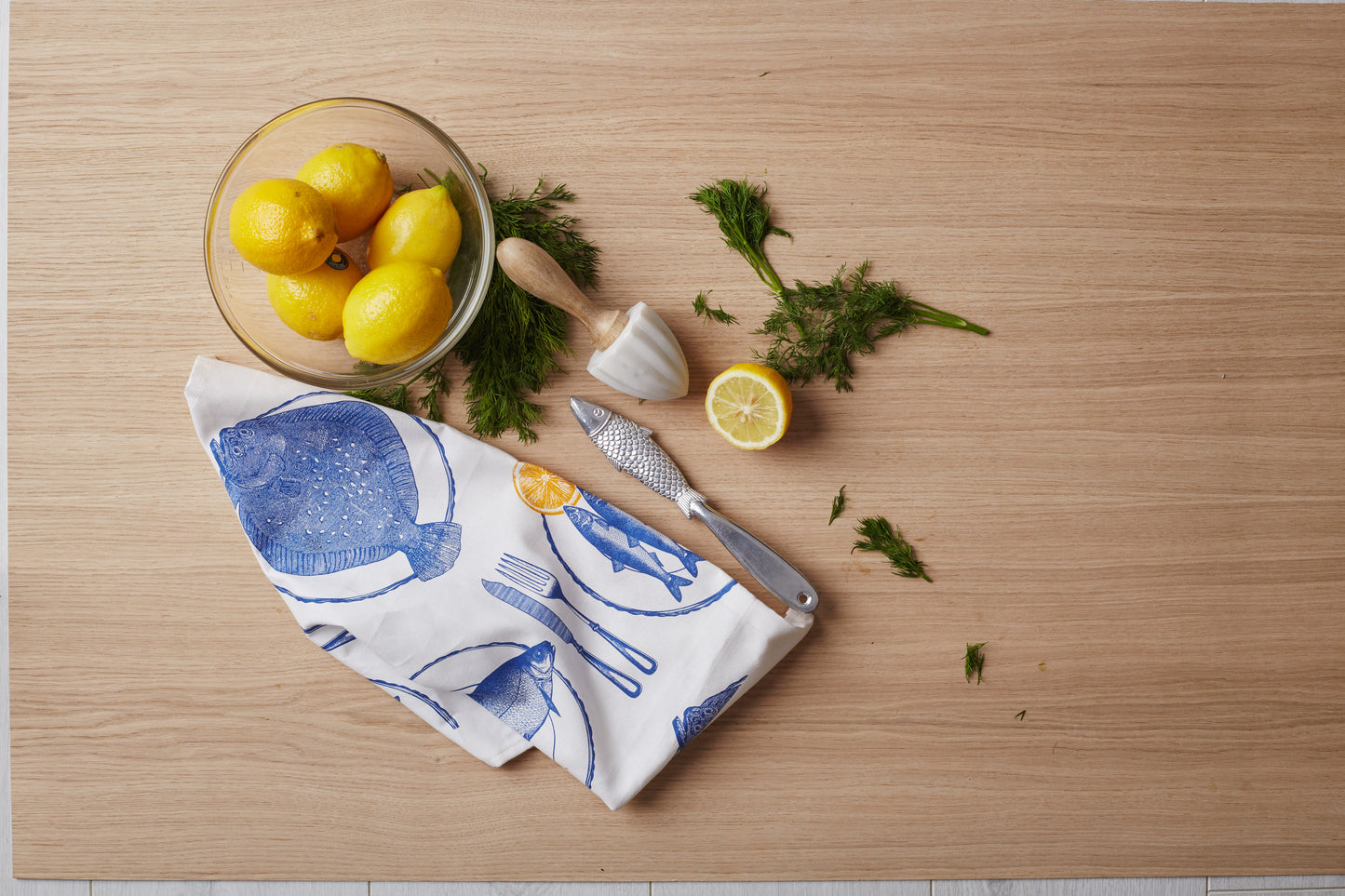 kitchentins - Thornback & Peel cotton tea towel printed with delft blue dinner plates with fish and zingy yellow slices of lemon