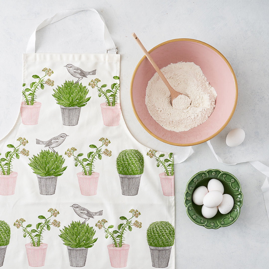 kitchentins - Thornback & Peel cotton apron printed with pink and green cactus and bird design with adjustable neck strap.