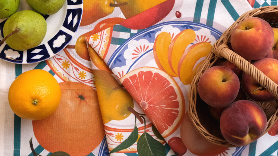 Kitchentins - Printer Johnson Fruits Tea towel including peaches, pears, and oranges with a basket of peaches.
