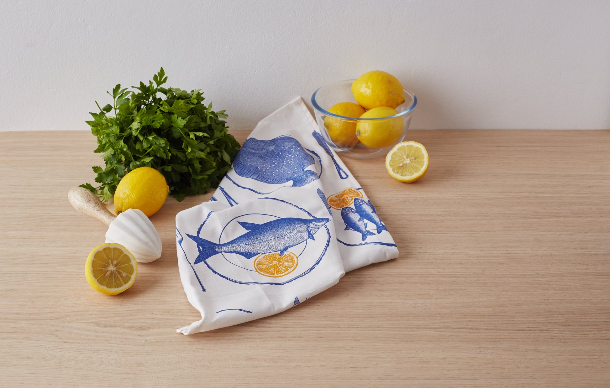 kitchentins - Thornback & Peel cotton tea towel printed with delft blue dinner plates with fish and zingy yellow slices of lemon
